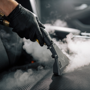 Firefly_Action shot of a detailer's hand using a precision steam cleaner nozzle on a heavily 590432